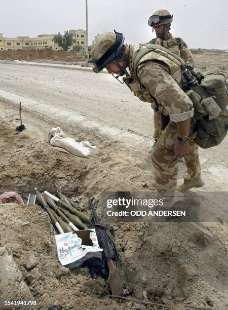 British soldiers inspect unexploded ordnance found in a trench at the Basra University compound 07 April 2003. British troops declared the battle for...