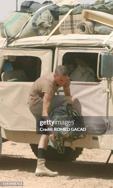 Army Specialist Michael Sukeforth from Woodland, Washington, takes a relief from the hot Iraqi desert temperature by stripping off his biochemical...