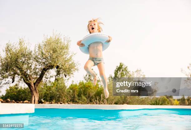 little boy jumping into swimming pool - swimming pool jump stock pictures, royalty-free photos & images