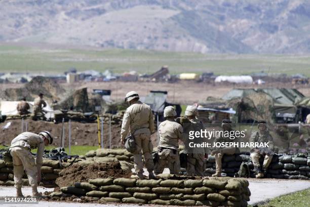 Soldiers from the 173rd Airborne Brigade lay down sand bags 01 April 2003 at an airstrip in the Kurdistan Democratic Party -controlled town of Harir,...