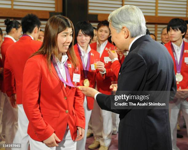 Emperor Akihito speaks to the gold medalist in women's wrestling freestyle 55kg Saori Yoshida during a tea party at the Imperial Palace on October...