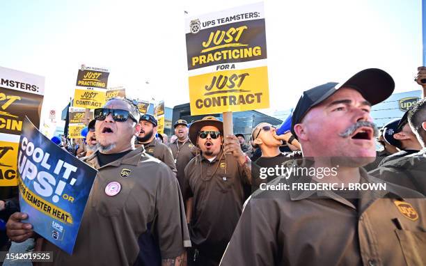 Workers hold placards at a rally held by the Teamsters Union on July 19, 2023 in Los Angeles, California, ahead of an August 1st deadline for an...