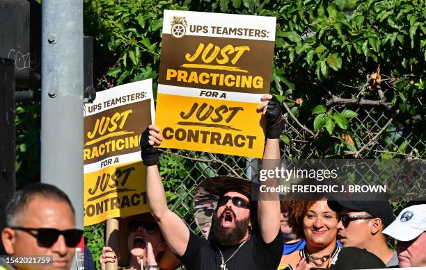 Workers hold placards at a rally held by the Teamsters Union on July 19, 2023 in Los Angeles, California, ahead of an August 1st deadline for an...