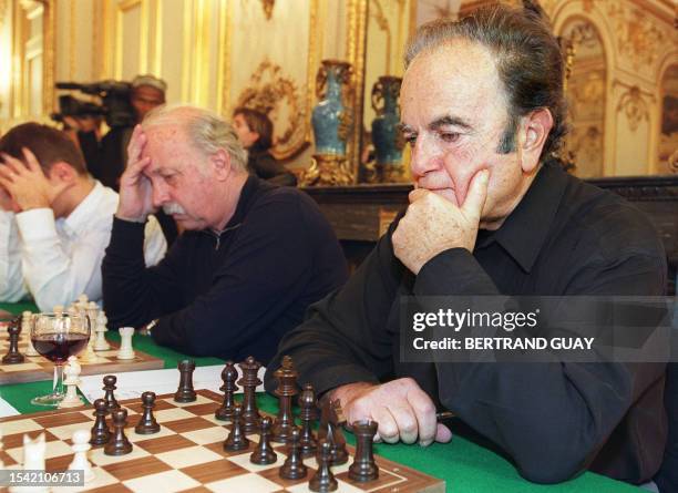 Le réalisateur Jean Becker et le chanteur et musicien Guy Béart jouent aux échecs, le 11 novembre 2000 au Sénat à Paris, lors d'une partie simultanée...