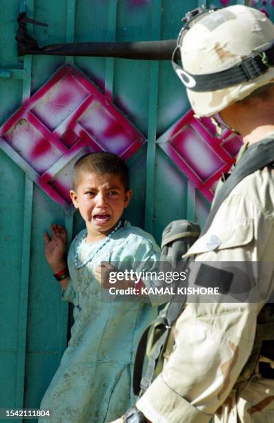 An Afghan girl cries in fear as an American soldier approaches to search her house in a village during Operation Deliberate Strike, some 60...