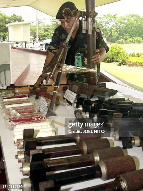 Soldier inspects 60mm mortar and other bomb-making materials at Armed forces headqurter in Manila 26 June 2003 that were reportedly discovered by...