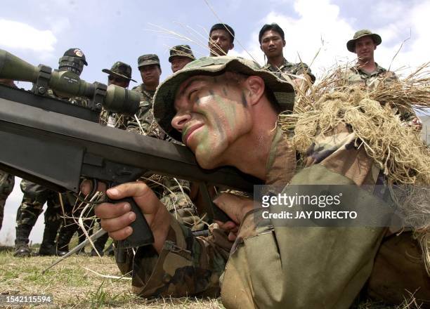 Marine sniper aims a 50 caliber Special Application Scope Rifle as his Filipino counterpart look on during the "Balikatan" 2003 joint US-Philippines...