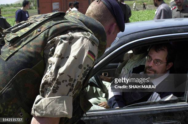 German International Security Assistance Force soldier checks a car at a check point near the spot of a blast in the outskirts of Kabul, 07 June...