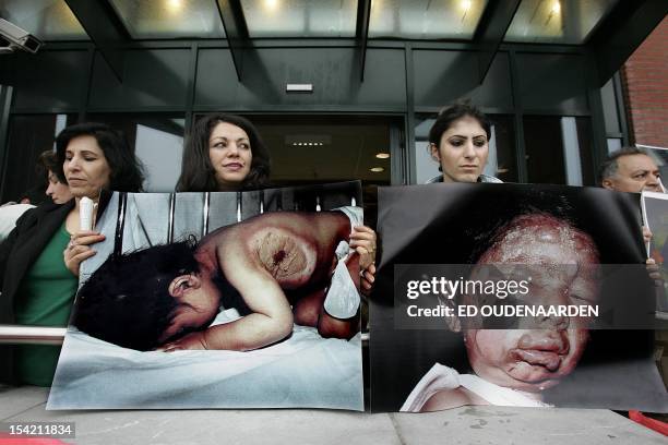 Iraqi Kurds, holding photos of victims of poison gas attacks by Iraqi government in 1988 in the town of Halabja, demonstrate in front of Rotterdam...