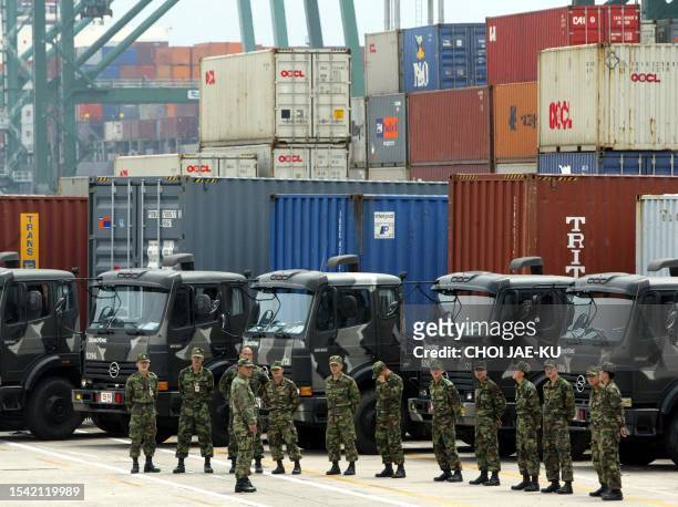 South Korean soldiers get set to stand in as truck drivers at the world's third largest container port in Busan, 13 May 2003, as a truckers strike...