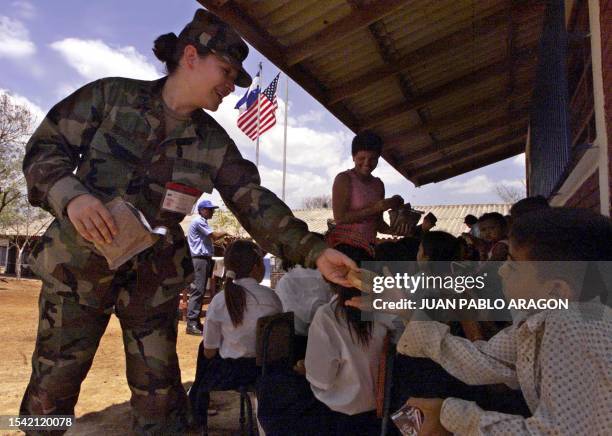 Soldier of the US Army Southern Command hands out bread to children of the "Las Lomas" community in the Leon department, 80 km west of Managua,...