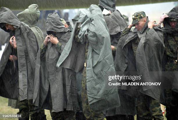 Group of Russian soldiers use their rain covers to protect from the heavy rain during the first day of the 6th Moscow International Air Show at the...