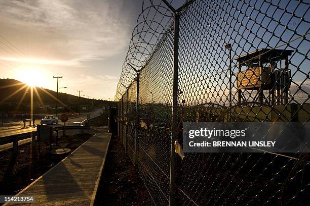 In this image reviewed by the US Military, The sun rises over Camp Delta detention compound which has housed foreign prisoners since 2002, at...