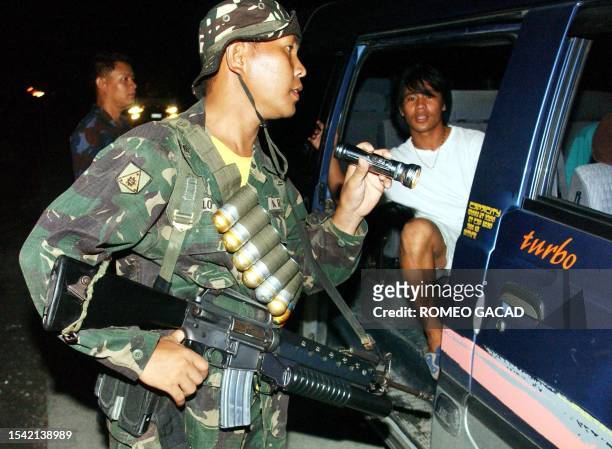 Philippine army soldier inspects a vehicle for weapons and explosives along the highway in Koronadal city in southern Philippine island of Mindanao,...