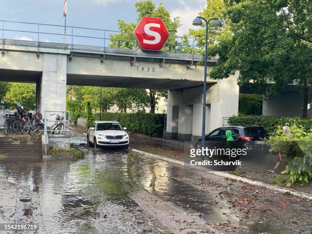 car driving through flooded road in scandinavia - heavy rain stockfoto's en -beelden