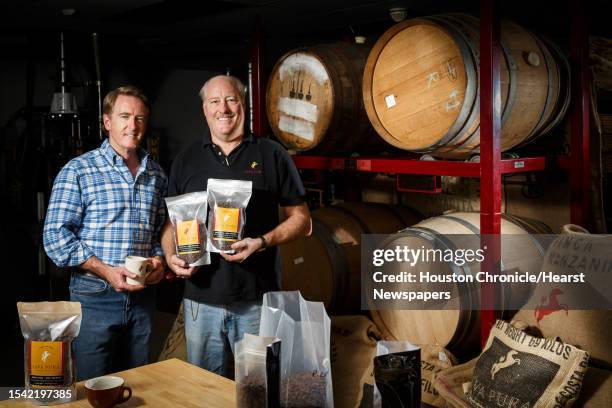 Java Pura coffee roasting partners Richard Colt, left, and Fielding Cocke stand in front of the wine and beer casks that are used to age their coffee...