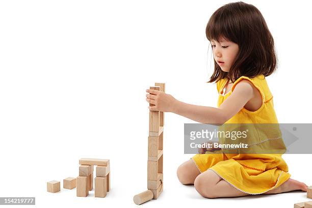 niña jugando con bloques de construcción aislada - sitting on floor fotografías e imágenes de stock