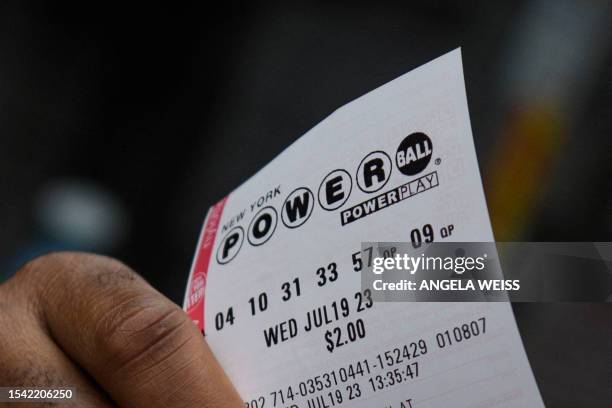 Person holds up their Powerball ticket in New York City on July 19, 2023. The Powerball jackpot has reached 1 billion USD for the July 19 drawing,...