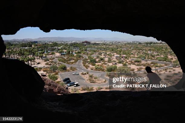 Hiker looks at the Phoenix skyline from the top of the Hole In The Rock trail during a record heat wave in Phoenix, Arizona, on July 19, 2023. The...