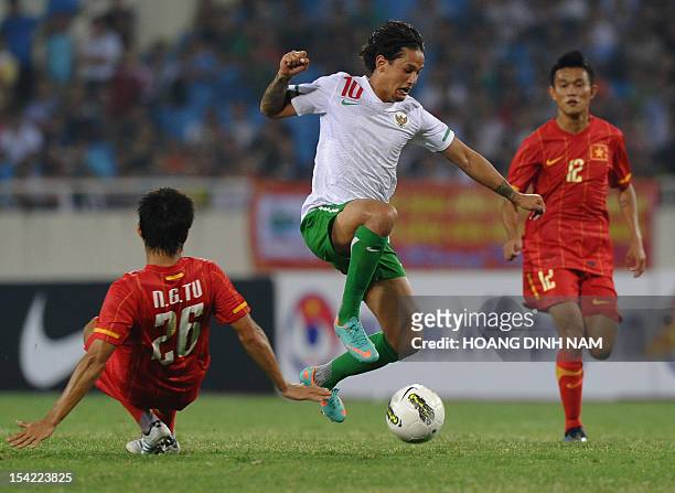 Indonesia's Irfan Haarys Bachdim leads an attack between Vietnam's Nguyen Gia Tu and Phan Thanh Hung during a friendly match at Hanoi's My Dinh...
