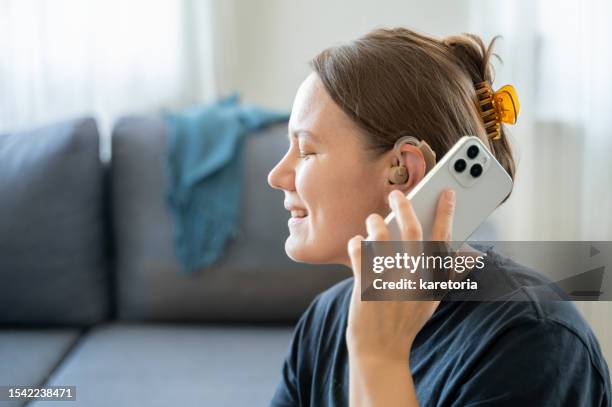 woman with hearing aid using smartphone - assistive technology stock pictures, royalty-free photos & images