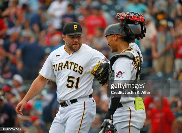 David Bednar of the Pittsburgh Pirates celebrates with Endy Rodriguez of the Pittsburgh Pirates after defeating the Cleveland Guardians during...