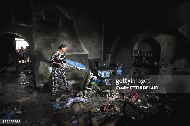 Woman tries to salvage items from burnt out Saida Manoubia shrine or zawiya in the western La Manouba suburb of the capital Tunis, on October 16,...