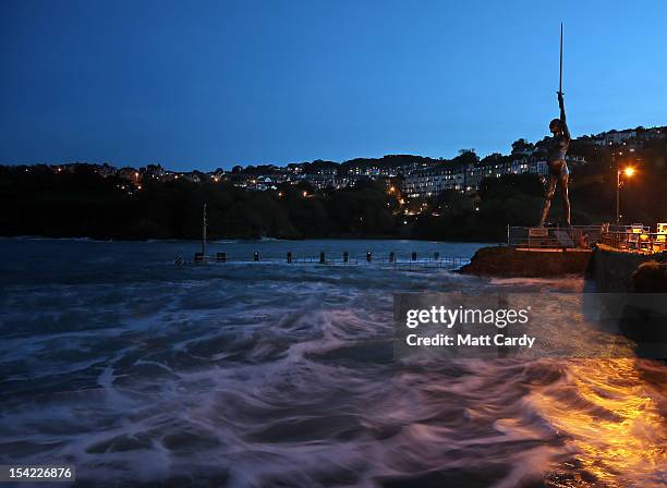 Waves lap beneath the harbour wall beside Damien Hirst's bronze sculpture of a pregnant woman on October 16, 2012 in Ilfracombe, England. The...