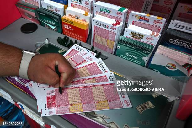 Woman fills in Powerball lottery tickets inside a store in Homestead, Florida on July 19, 2023. The Powerball jackpot has reached 1 billion USD for...