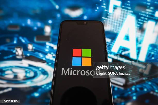 In this photo illustration a Microsoft logo is displayed on a smartphone with Artificial Intelligence symbols in the background.