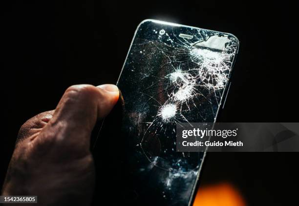 hand holding broken mobile phone in light beam. - broken stock pictures, royalty-free photos & images