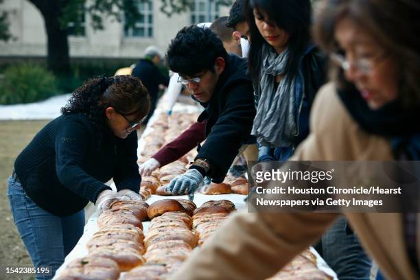 Volunteers place nearly 1400, two-foot-long, Rosca de Reyes weighing a total of 1000 lbs. In a giant line while trying to form the world's largest...
