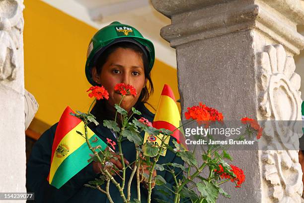 October 16: A student of the La Paz Art School holds Bolivian and Spanish flags while she waits for Queen Sofia of Spain to visit to the National Art...