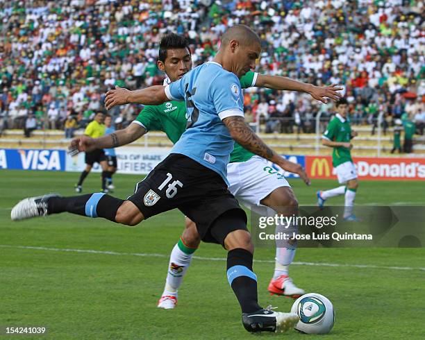 Maximiliano Pereira of Uruguay and Luis Mendez of Bolivia fight for the ball during a match between Uruguay and Bolivia as part of the South American...