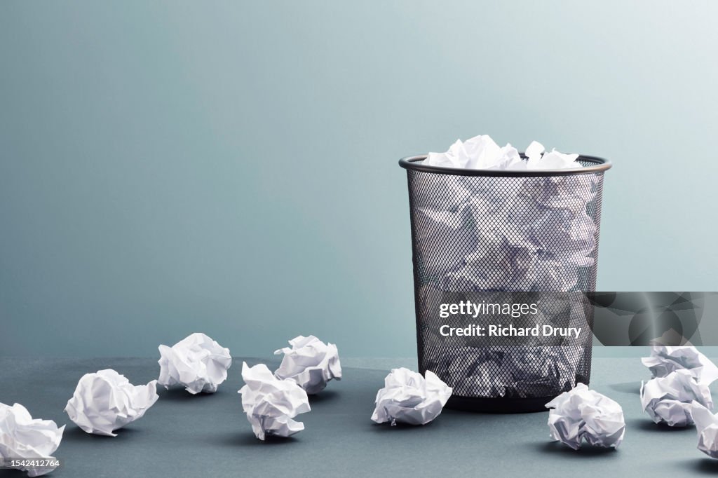 A waste paper basket full of waste paper