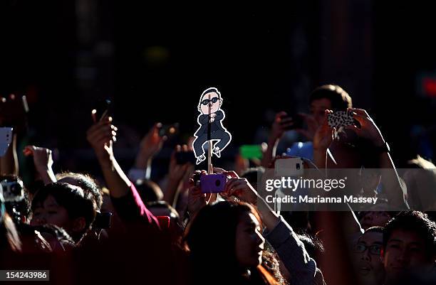 Fans hold up signs as South Korean rapper Psy, performs live on Channel 7's "Sunrise" at Martin Place on October 17, 2012 in Sydney, Australia.