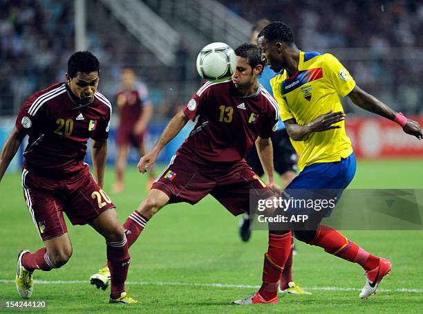 Ecuadorean forward Jaime Ayovi vies for the ball with Venezuelan defender Grenddy Perozo and Venezuelan Greco Perez during their FIFA World Cup...