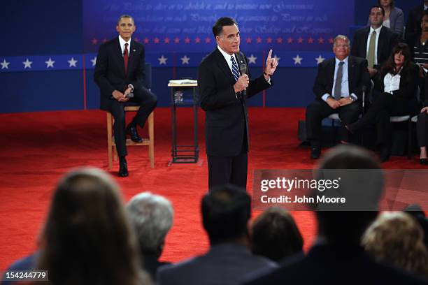 Republican presidential candidate Mitt Romney speaks as U.S. President Barack Obama listens during a town hall style debate at Hofstra University...