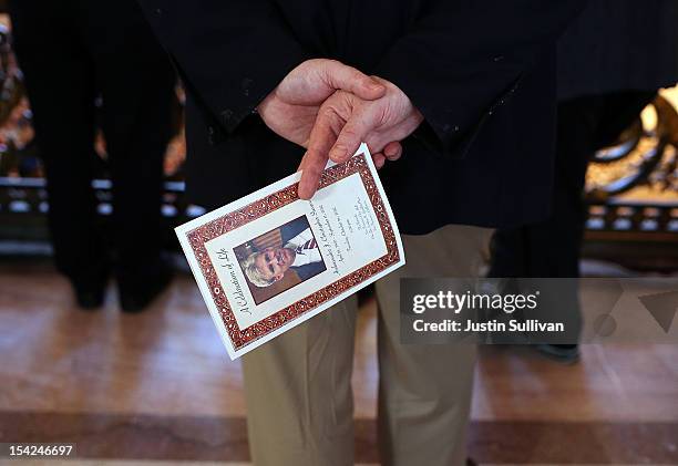 Man holds a program during a memorial service for the U.S. Ambassador to Libya Christopher Stevens at San Francisco City Hall on October 16, 2012 in...