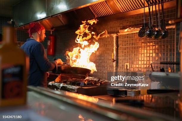 the chef cooking in a flaming pan - turkish people cafe stock pictures, royalty-free photos & images