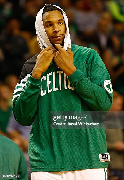 Jared Sullinger of the Boston Celtics watches the game with his head wrapped in a towel during the preseason game against the Brookyln Nets on...