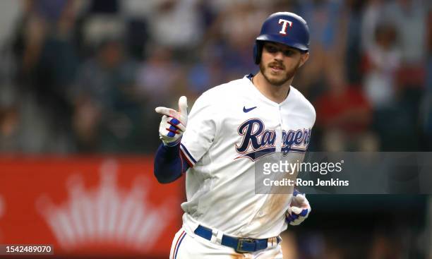 Jonah Heim of the Texas Rangers points to teammates after hitting a three-run home run against the Tampa Bay Rays during the eighth inning at Globe...