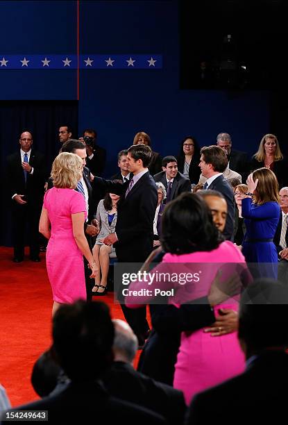 Republican presidential candidate Mitt Romney is greeted by his wife Ann Romney and son Matt Romney as U.S. President Barack Obama hugs wife Michelle...