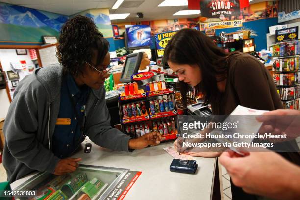 Anne Porembski gets help buying a lottery ticket from Veronica Johnson at the Valero Gas Station at Montrose and Westheimer before the $355-million...