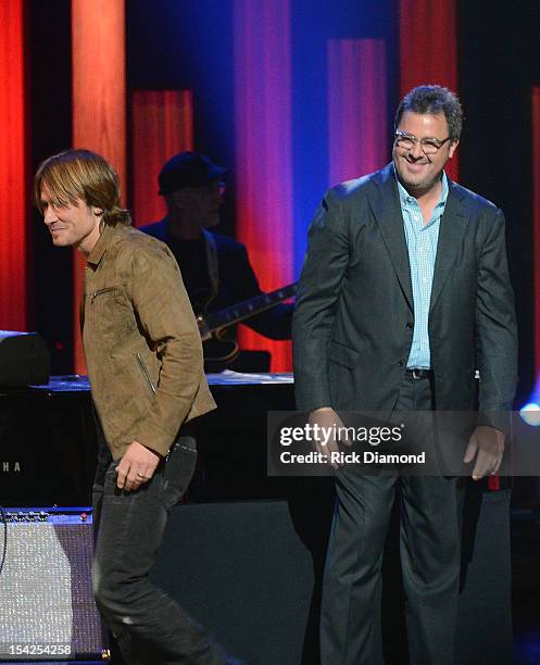 Newest member of the Grand Ole Opry Darius Rucker's gets surprised by Keith Urban as Vince Gill watches on during Rucker's induction into The Grand...