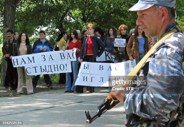 South Ossetin demonstrators hold placards reading "We are ashamed of you ", "We didn't invite you ", "We don't need you" during an anti-Georgian...