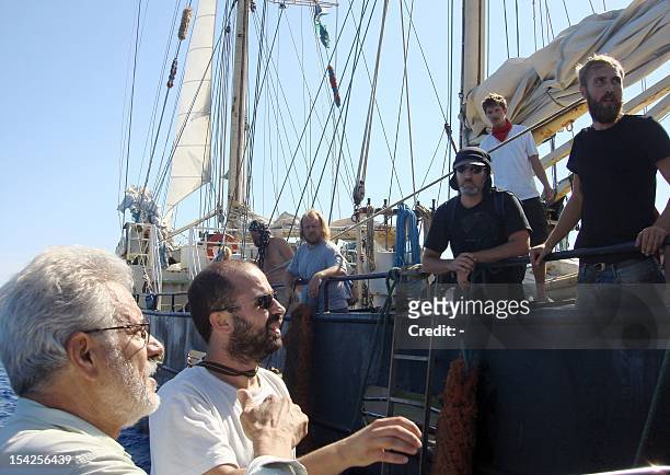 Greek pro-Palestinian activist Vassilis Pissias speaks on October 16. 2012 with the international crew members of the SV Estelle as he brings water...