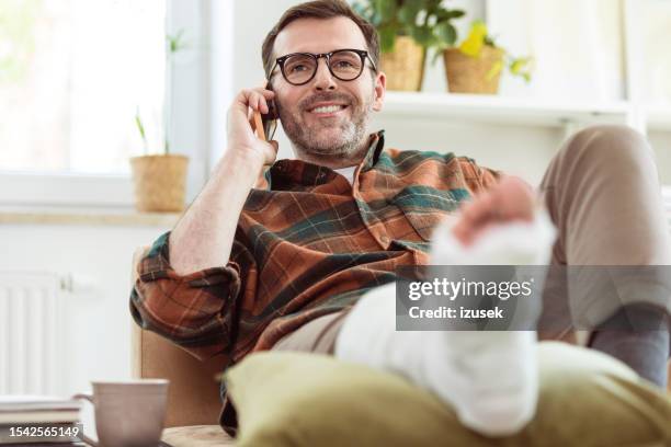 mature man with broken leg at home - gypsum stock pictures, royalty-free photos & images