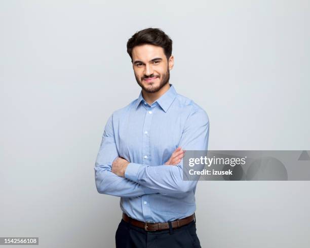 joven hombre de negocios sonriendo a la cámara - camisa azul fotografías e imágenes de stock