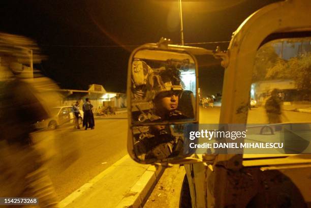 Military from 1-22 battalion, 4th Infantry Division secure a street shortly after discovering an improvised explosive device in Saddam Hussein's...